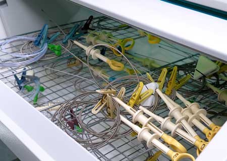 Laboratory technician performing microbiological testing inside sterile hood at C.G. Laboratories